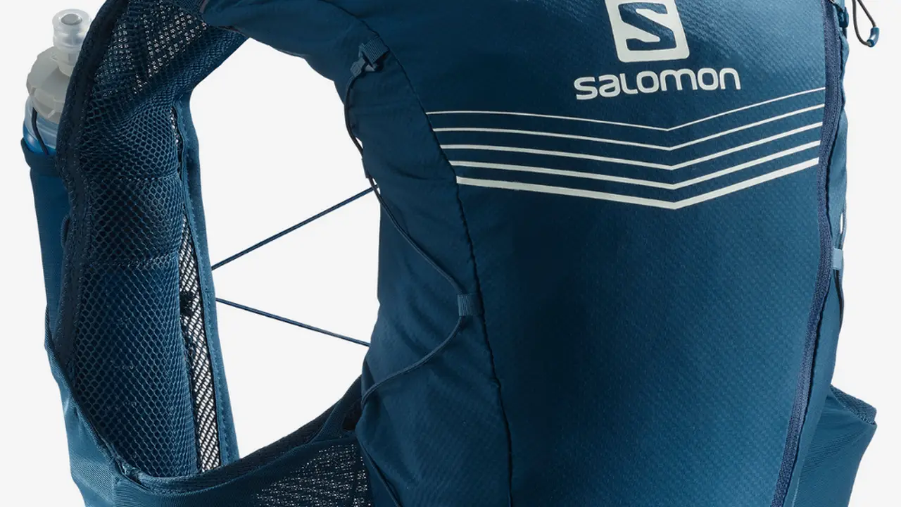 blue bowl of black bean beef tortilla soup on a board with cilantro and shredded cheese in background